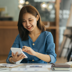 Woman calculating her finances at a table with a laptop in front of her